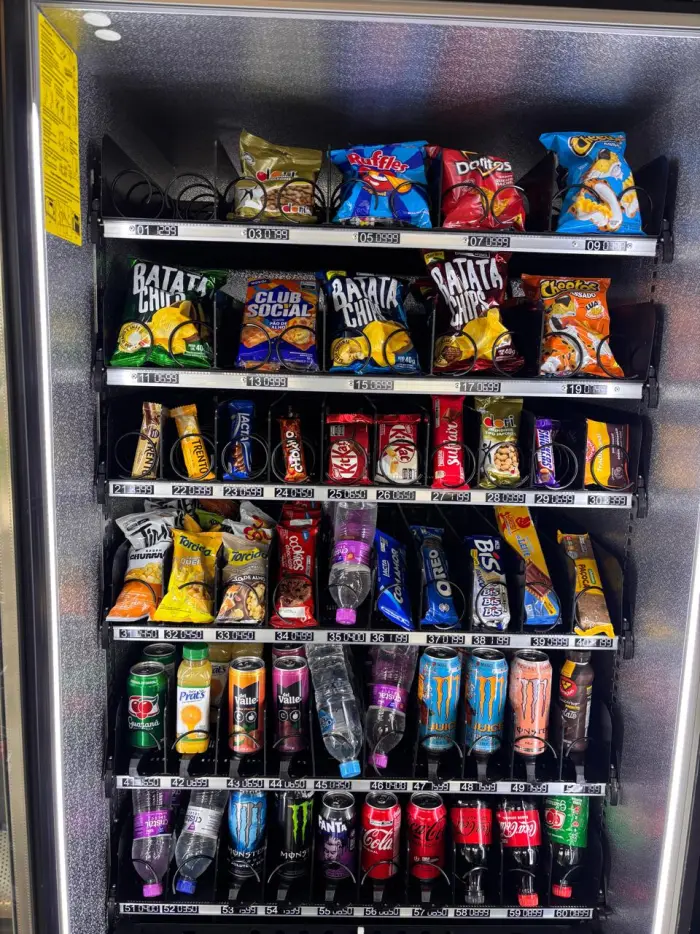 Máquina de venda automática com snacks e bebidas disponíveis na lavanderia